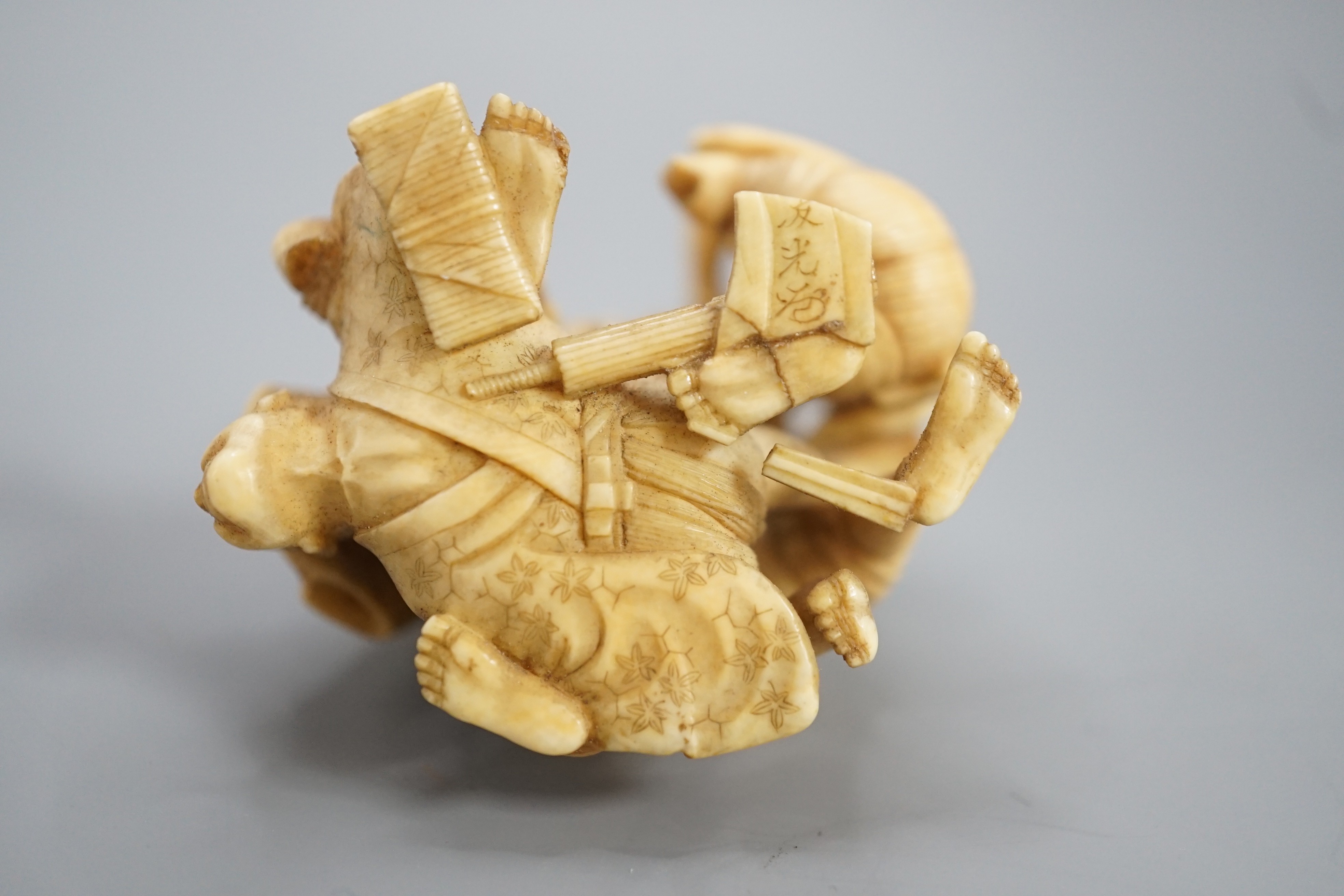 A Japanese ivory group of four men fighting, signed, Meiji period, 5.5cm
